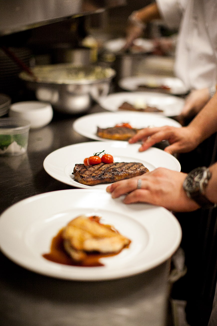 Chef Plating Gourmet Steak in Professional Kitchen