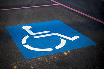 Blue Handicap Parking Symbol Painted On Dark Asphalt Surface