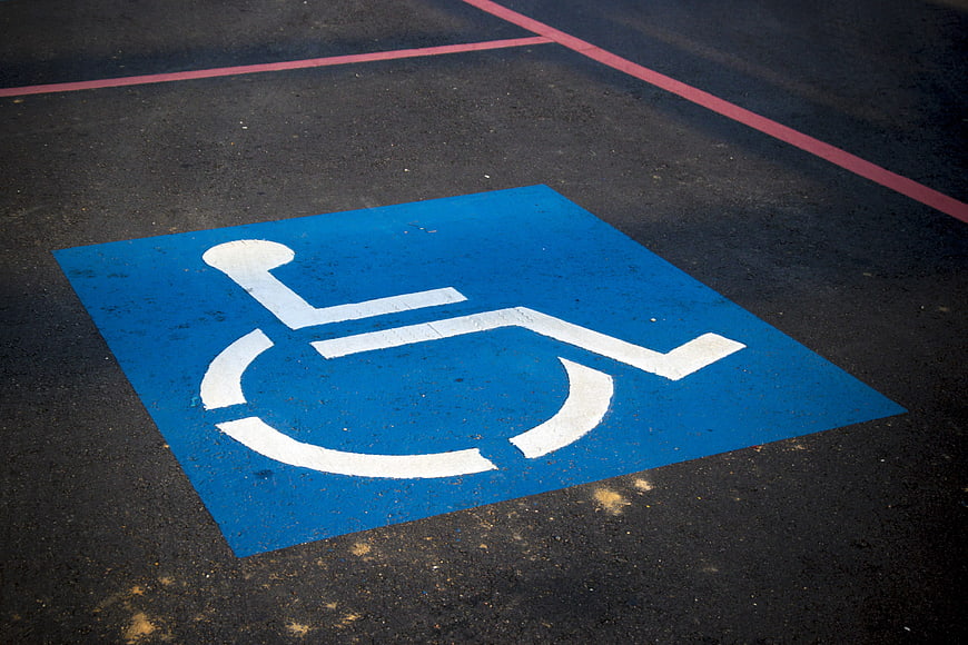 Blue Handicap Parking Symbol Painted On Dark Asphalt Surface