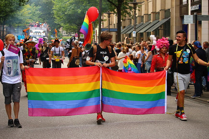 Young Men Carrying Large Rainbow Flag at Pride Parade