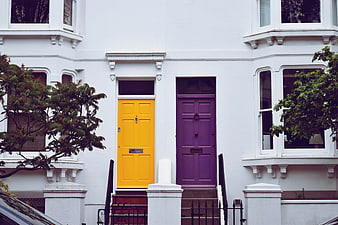 Colorful yellow and purple doors on white townhouse facade