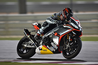 Motorcycle racer leaning into a turn on a race track
