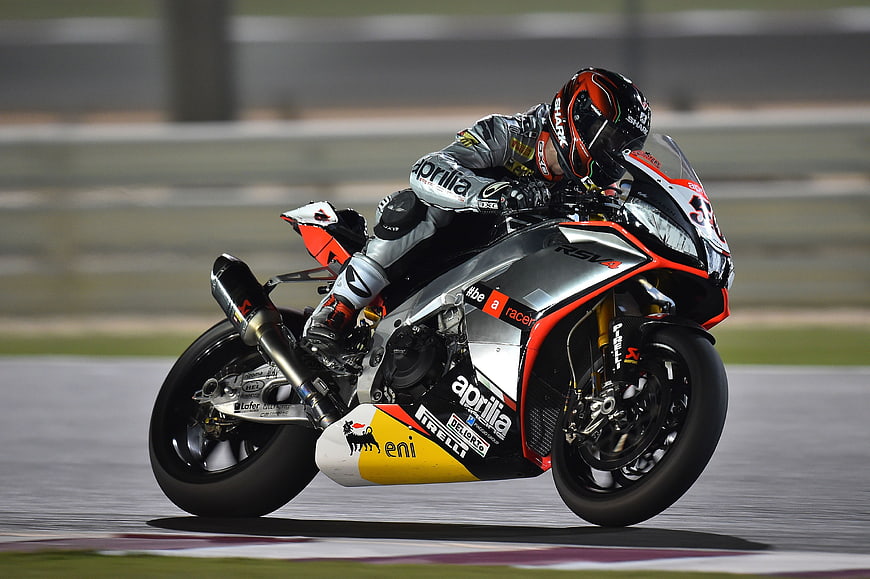 Motorcycle racer leaning into a turn on a race track