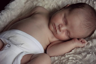Sleeping newborn baby on soft white blanket