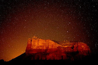 Red Rock Butte Illuminated Under Starry Night Sky