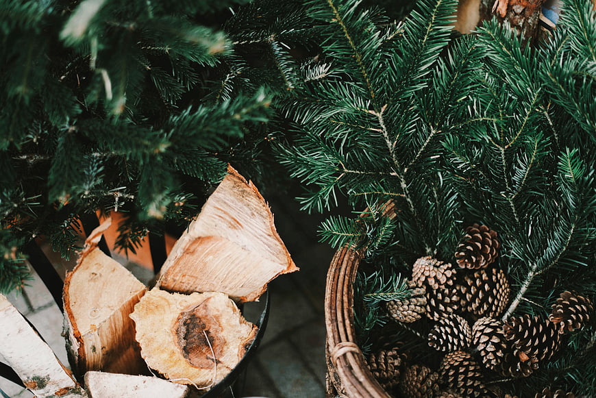 Christmas pine branches, pinecones, and firewood in baskets