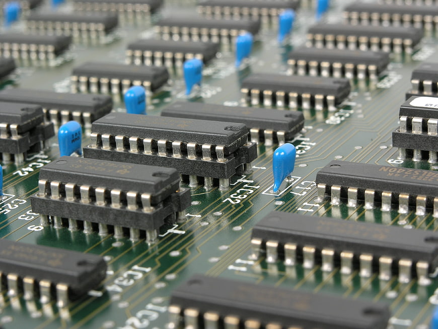 Close-up of green circuit board with microchips and capacitors