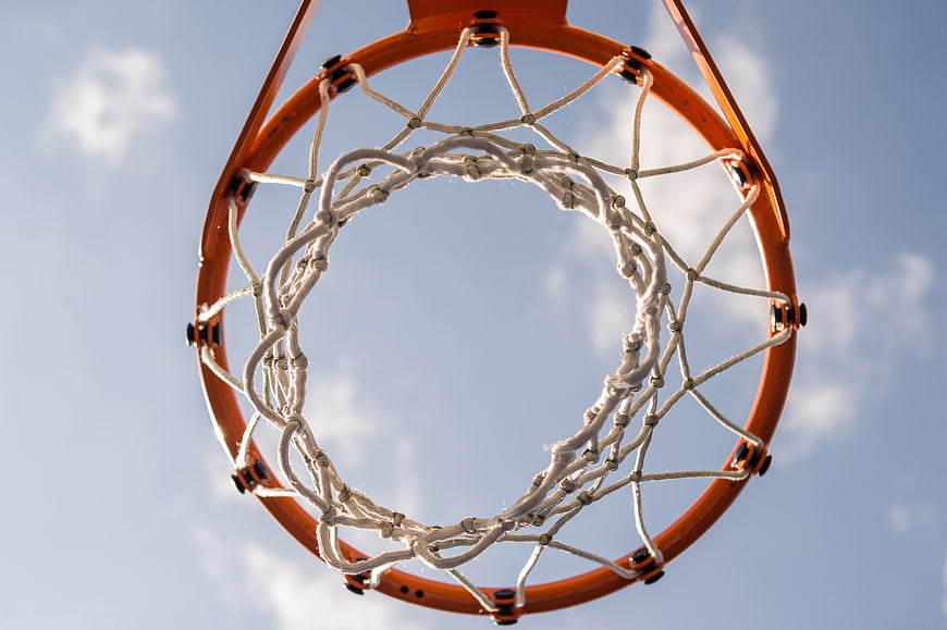 Low angle view of basketball hoop and net against blue sky