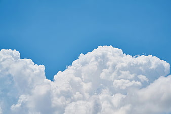 Fluffy White Cumulus Clouds Against Blue Sky