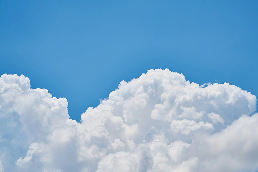 Fluffy White Cumulus Clouds Against Blue Sky