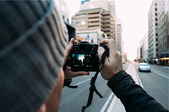 Photographer capturing city street with DSLR camera