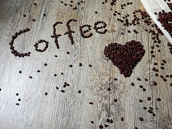 Coffee beans spelling love on rustic wooden background