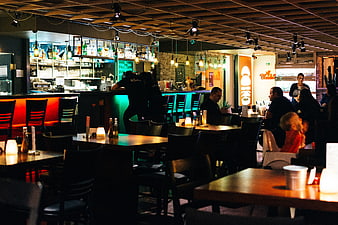 Dimly lit restaurant bar interior with patrons dining