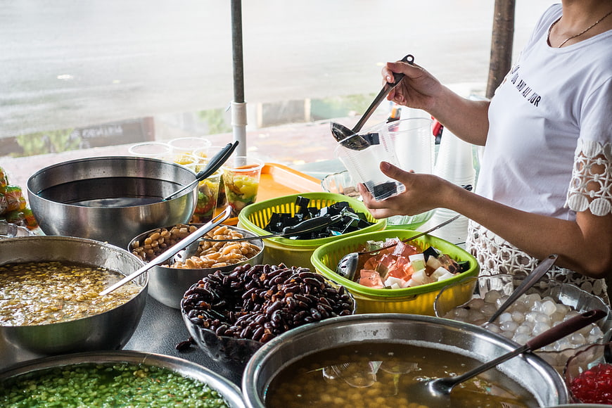 Vietnamese street food vendor preparing traditional sweet dessert Che