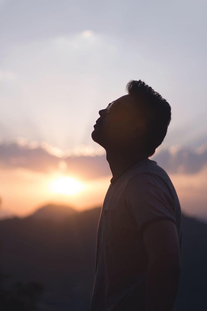 Silhouette of Man Looking Up at Sunset Sky