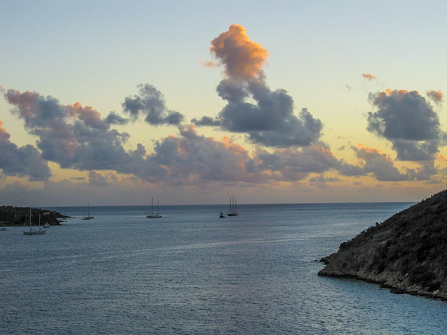 Serene Caribbean Sunset with Sailboats and Dramatic Clouds