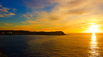 Golden Sunset Over Coastal Ocean with Silhouette