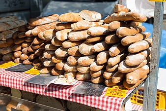 Fresh baguettes stacked at a farmers market stall