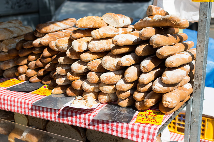 Fresh baguettes stacked at a farmers market stall