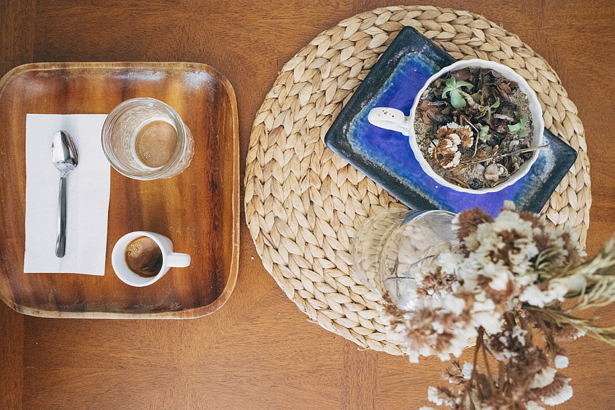 Top view of coffee, espresso, and dried flowers on wooden table