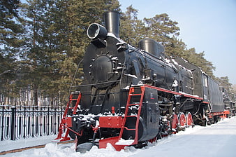 Vintage Black Steam Locomotive in Snowy Winter Landscape