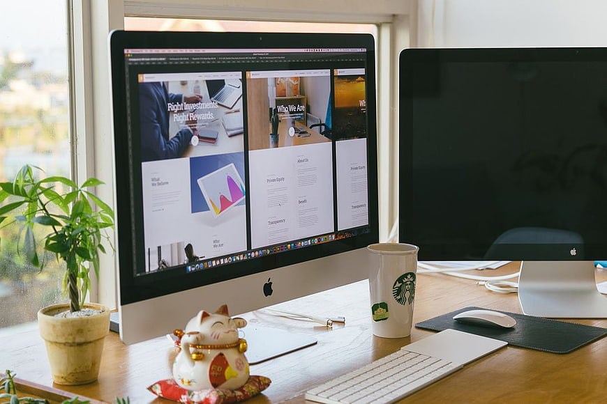Web design workspace with Mac computer and lucky cat figurine