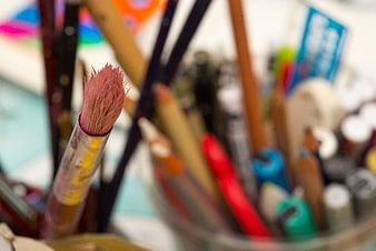 Close-up of pink paintbrush tip in art supplies container