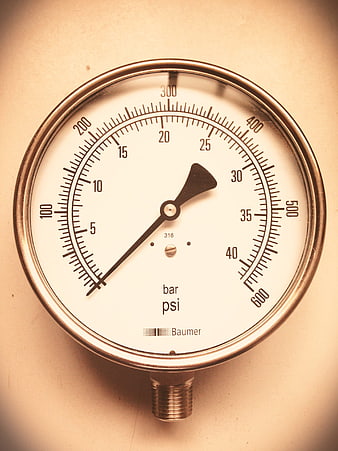 Close-up of a vintage industrial pressure gauge with bar and psi scale