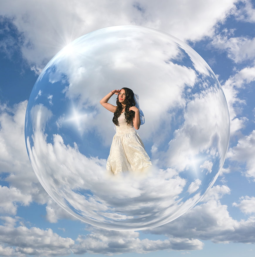 Woman in white dress inside a giant bubble in the sky