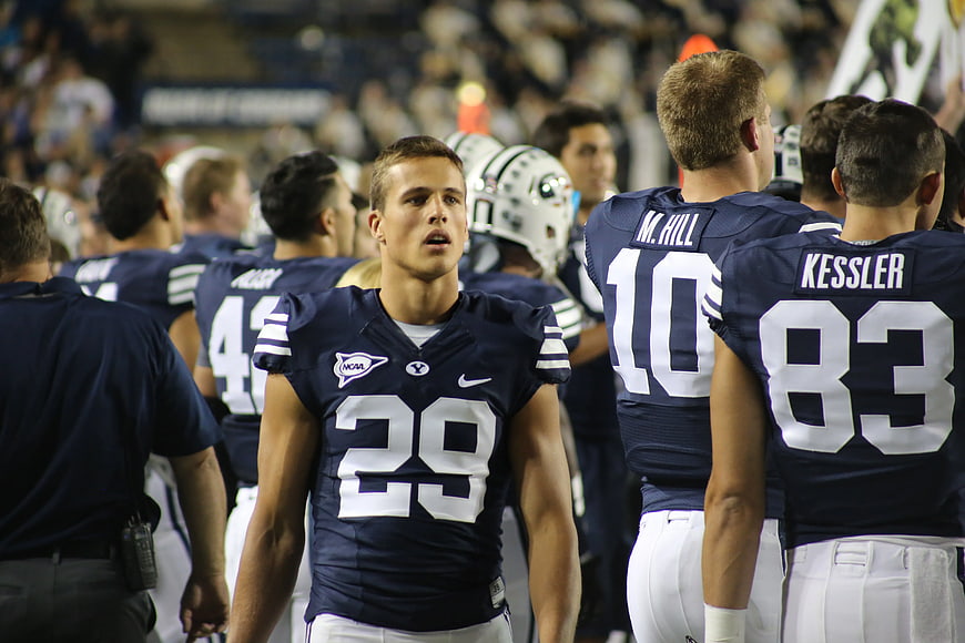 American Football Player in Navy Jersey Walking on Field
