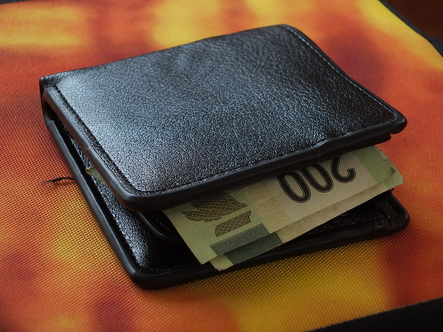 Black Leather Wallet with 200 Peso Banknote on Orange Background