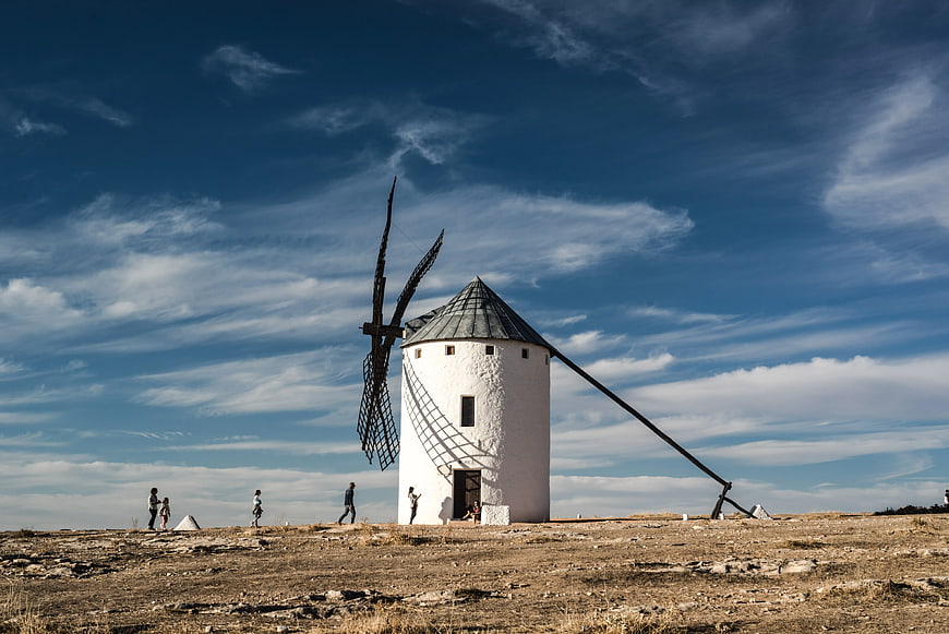 White Windmill on Arid Hill Under Blue Sky