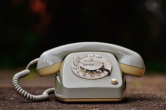 Vintage Gray Rotary Telephone on Wooden Surface