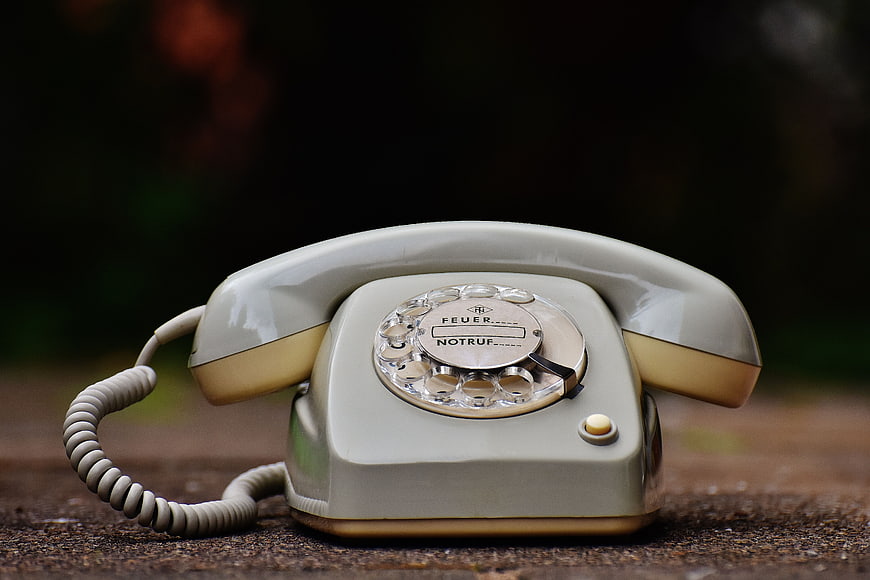 Vintage Gray Rotary Telephone on Wooden Surface