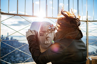 Woman Looking Through Coin-Operated Binoculars at City View