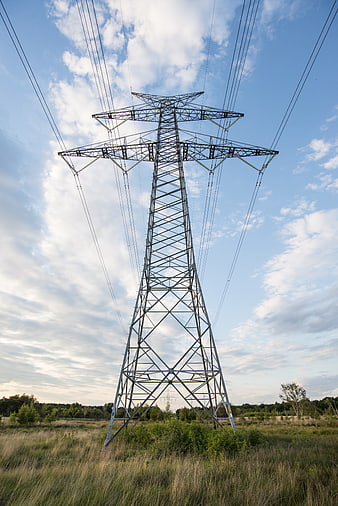 High Voltage Power Pylon in Grassy Field