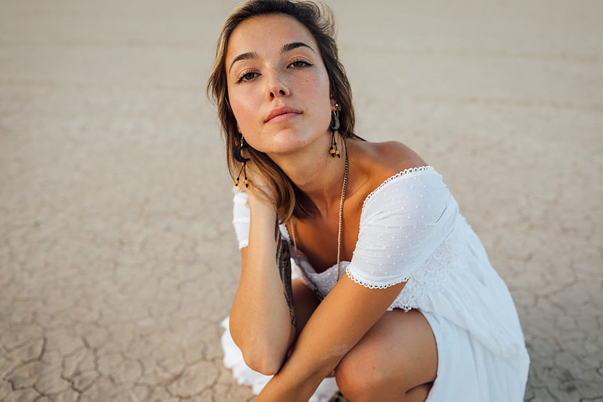 Portrait of Woman in White Dress on Desert Ground