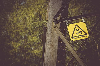 Yellow Danger of Death Sign on Metal Pylon