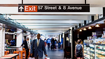 Exit sign for 57th Street and 8th Avenue in busy subway station
