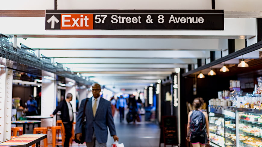 Exit sign for 57th Street and 8th Avenue in busy subway station