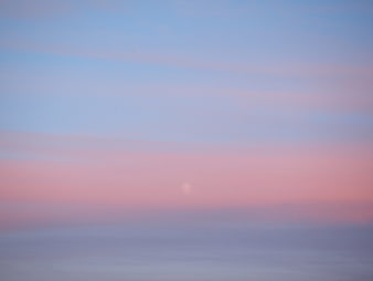 Soft pastel pink and blue sunset sky with haze