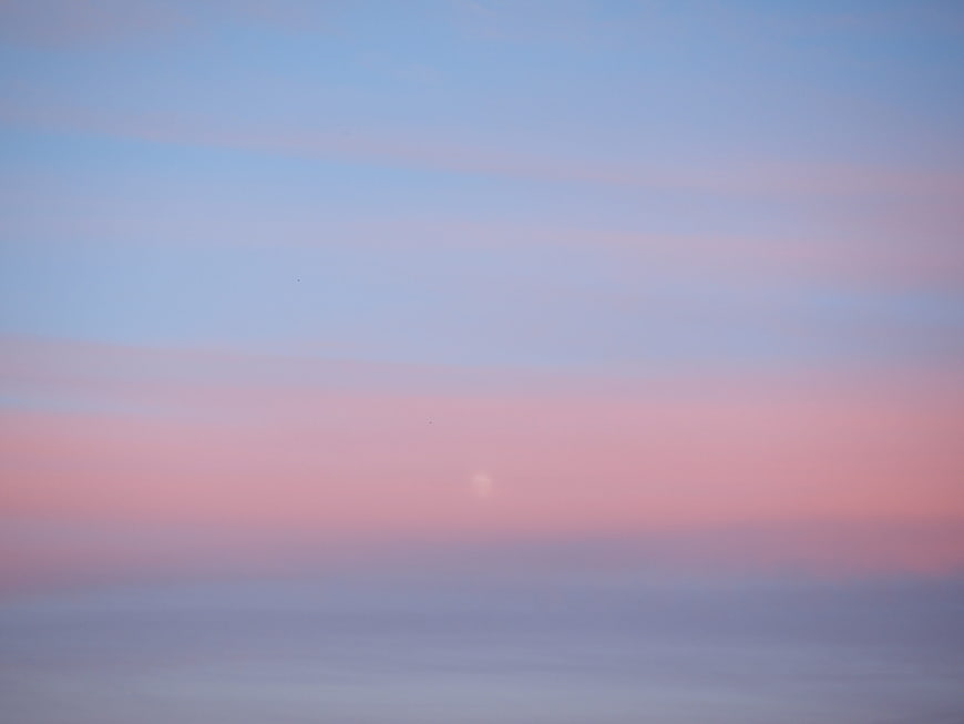 Soft pastel pink and blue sunset sky with haze