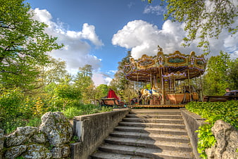 Vintage Carousel in Park with Stone Steps and Blue Sky