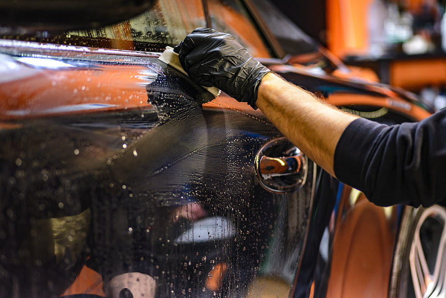 Close-up of hand applying car window tint film