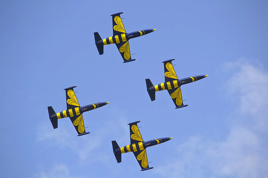 Yellow and Black Aerobatic Jets Flying in Formation