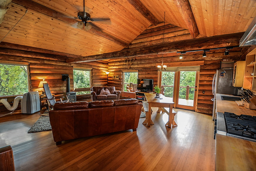 Rustic Log Cabin Interior With Leather Sofa And Kitchen