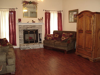 Cozy Living Room Interior With Stone Fireplace And Wooden Armoire