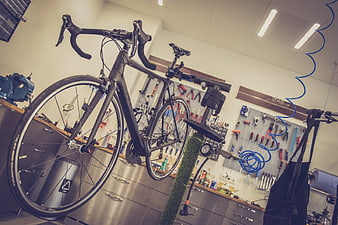 Black Road Bike on Repair Stand in Workshop