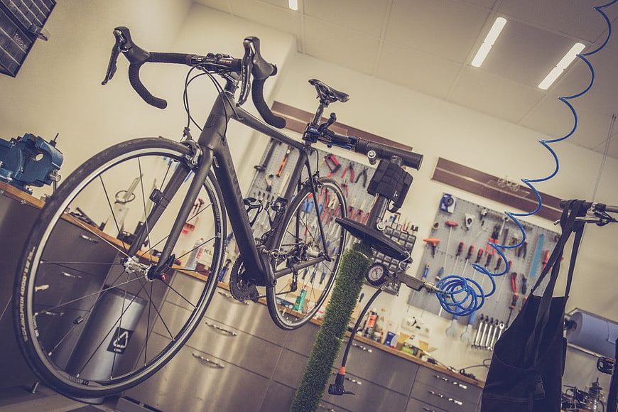 Black Road Bike on Repair Stand in Workshop