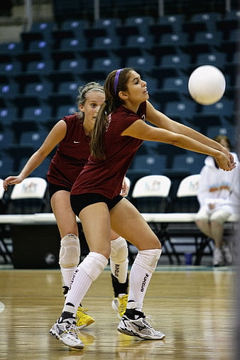 Female volleyball player setting ball during indoor match